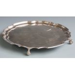 Large hallmarked silver salver with shaped edge and raised on four scroll feet, Birmingham 1973