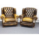 Two Chesterfield button back, club style arm chairs finished in chestnut brown / tan leather with