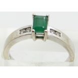 A 14k white gold ring set with an emerald cut emerald and diamonds to the shoulders, 3.6g, size N