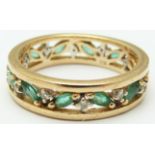 A 9ct gold eternity ring set with marquise cut emeralds and diamonds, in original Brooks & Bentley