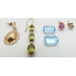 Two emerald cut aquamarines each approximately 2.5cts, a yellow metal earring set with peridot,