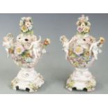 A pair of continental figural potpourri with applied flower decoration, with anchor marks to base,