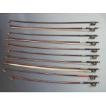 Eight round stick violin bows with various button types, together with two octagonal bows, all