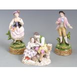 A pair of continental figures of sweethearts with crossed swords to base and a similar group with