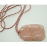 Chinese rose quartz carving of a bat and peaches on a rope necklace, 5.5 x 3.5cm
