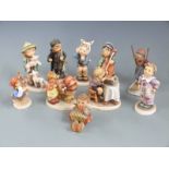 A collection of Goebel Hummel figures including Skier, Cello Player etc