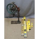 A vintage hand cranked pillar drill and five spirit levels
