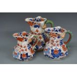 Three Masons graduated octagonal jugs with snake handles, tallest 23cm