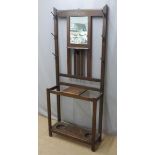 An oak hall stand with mirror and umbrella / stick wells, W76 x D25 x H187cm
