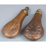 Two copper and brass powder flasks, both with embossed decoration to each side, largest 19cm long.