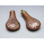 Two copper and brass powder flasks both with embossed decoration to both sides, largest 20cm long.