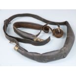 Two Bandolier type leather and brass shot flasks both with shoulder straps, largest 50cm long.