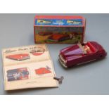 Schuco Radio 4012 clockwork tinplate car car with maroon body and red interior containing a Thorens