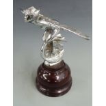 Winged nymph riding a winged wheel vintage car mascot, on turned wooden base, overall height 20.5cm