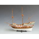 Three wooden scratch built hand painted masted sailing ships, two in display cases, largest 55cm