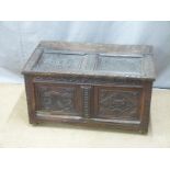 A 17th/18thC carved oak two panel trunk with interior nine division cellarette style compartment,
