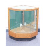 An early 20thC glazed oak haberdashery/shop fitting display cabinet with canted corners to suit