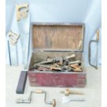 A metal bound trunk containing vintage tools including woodworking saws, Marsden Brothers saw, bit