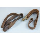 Two Bandolier type leather and brass shot flasks both with shoulder straps, largest 45cm long.