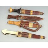 Four African tribal daggers, each with leather scabbard and shaped handle