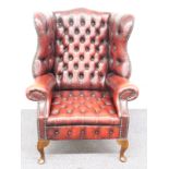 Chesterfield wing back armchair raised on front cabriole legs and swept rear legs, H112cm