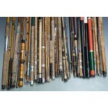 A collection of fishing rods, holdalls, landing net handles etc, including vintage cane rods,
