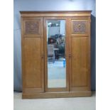 Art Nouveau carved oak wardrobe with bevelled glass mirror, interior drawers and dentil cornice, W18