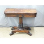 19thC rosewood fold over card table raised on a turned support and quatrefoil base with scrolling