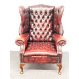 Chesterfield wing back armchair raised on front cabriole legs and swept rear legs, H112cm