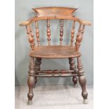 A 19th/20thC elm-seated armchair raised on turned legs