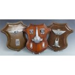 Three shield shaped displays of car badges including Rolls Royce, Bentley, Austin, Rover and Morris,