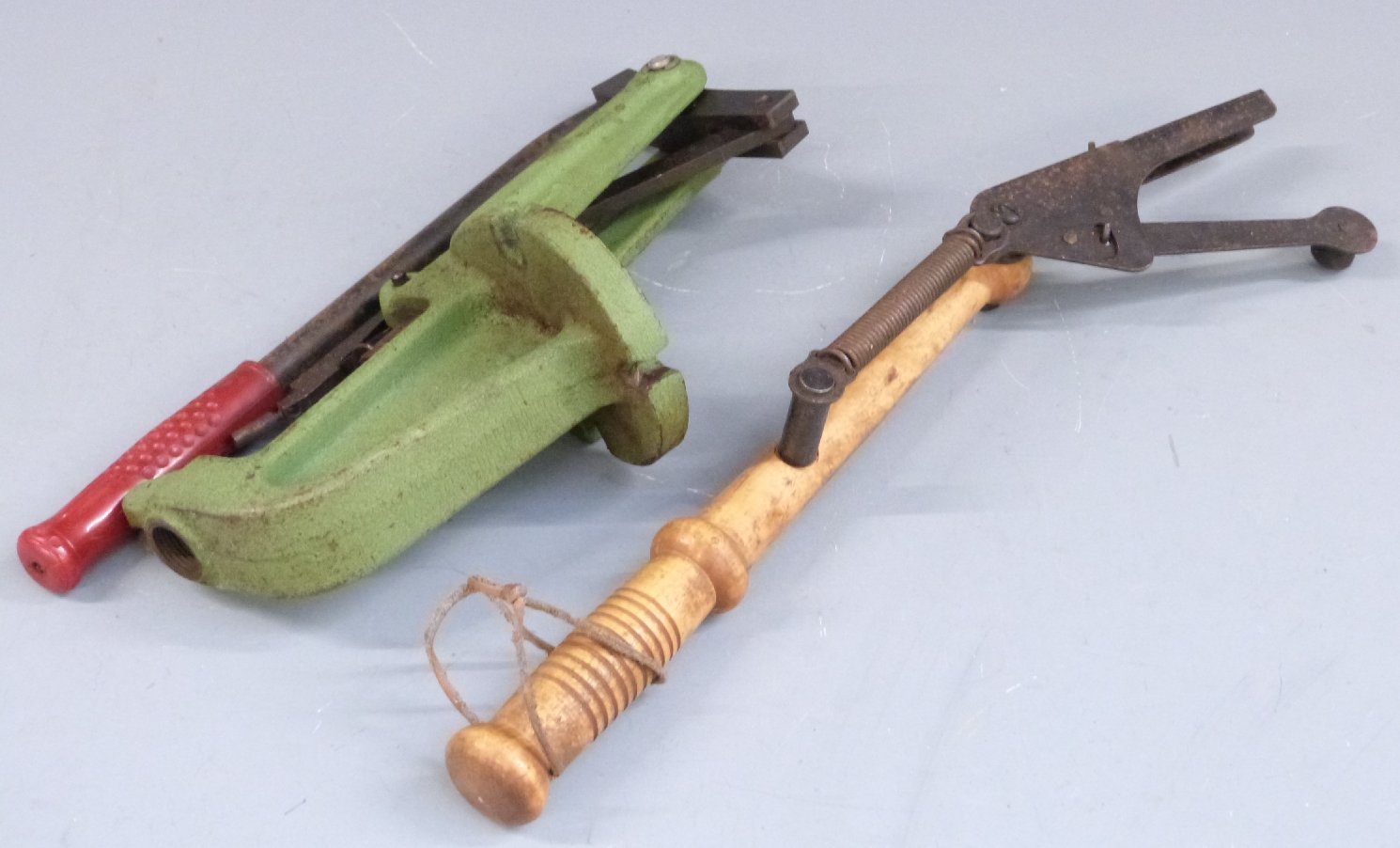 A handheld clay pigeon launcher together with a Redding shotgun cartridge re-loading tool.
