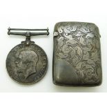A hallmarked silver vesta case with scrolling foliate decoration and a WWI war medal named to 1335