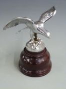 Eagle resting on a rocky outcrop vintage car mascot, marked to base Reg No. 803142, on turned wooden