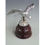 Eagle resting on a rocky outcrop vintage car mascot, marked to base Reg No. 803142, on turned wooden