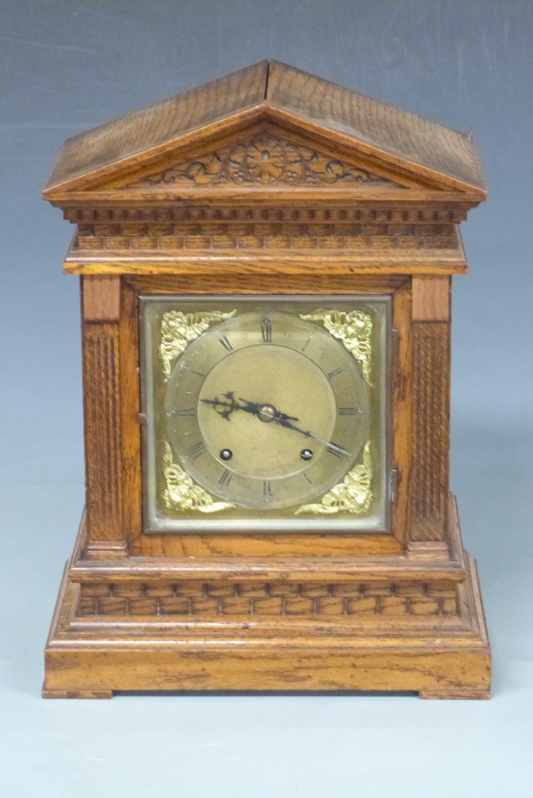 Oak-cased mantel clock with apex top, Roman silvered dial, Arabic minutes, cherub spandrels to