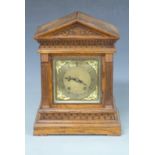 Oak-cased mantel clock with apex top, Roman silvered dial, Arabic minutes, cherub spandrels to