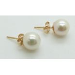 A pair of 9ct gold earrings set with a pearl to each