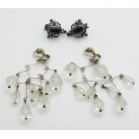 A pair of silver earrings set with amethysts and a pair of crystal chandelier earrings
