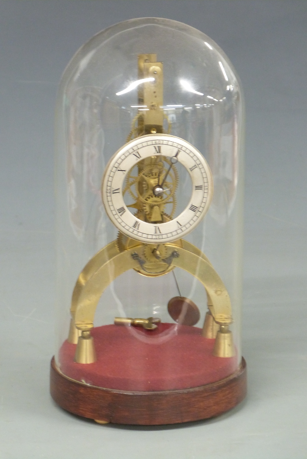 Late 19th/early 20thC skeleton clock under glass dome, with Roman numerals to silvered chapter ring,