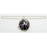 A large oval cut amethyst (175ct) set into a silver floral pendant setting, on silver chain