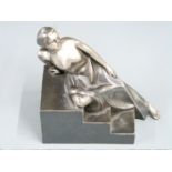 Art Deco style cast silvered metal figure of a female nude reclining on steps, H15.5cm