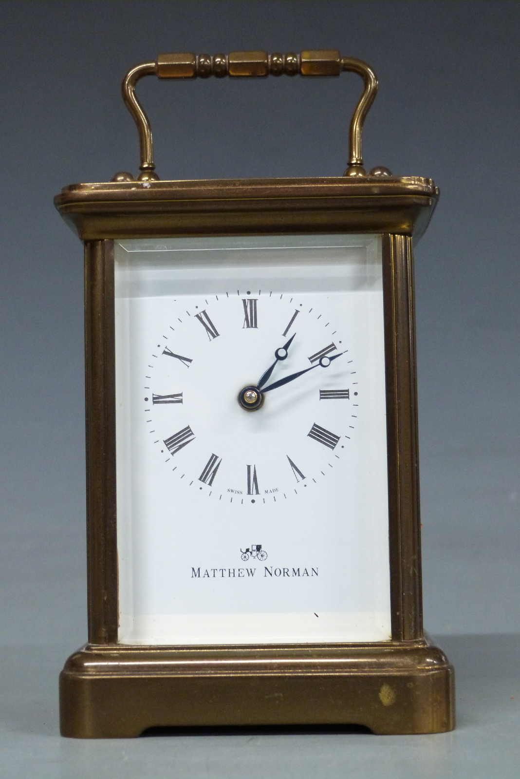 A 20thC brass carriage clock by Matthew Norman in corniche style case, the Roman enamel dial with