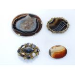 A large Victorian brooch set with a panel of agate, two pinchbeck brooches set with agate and a