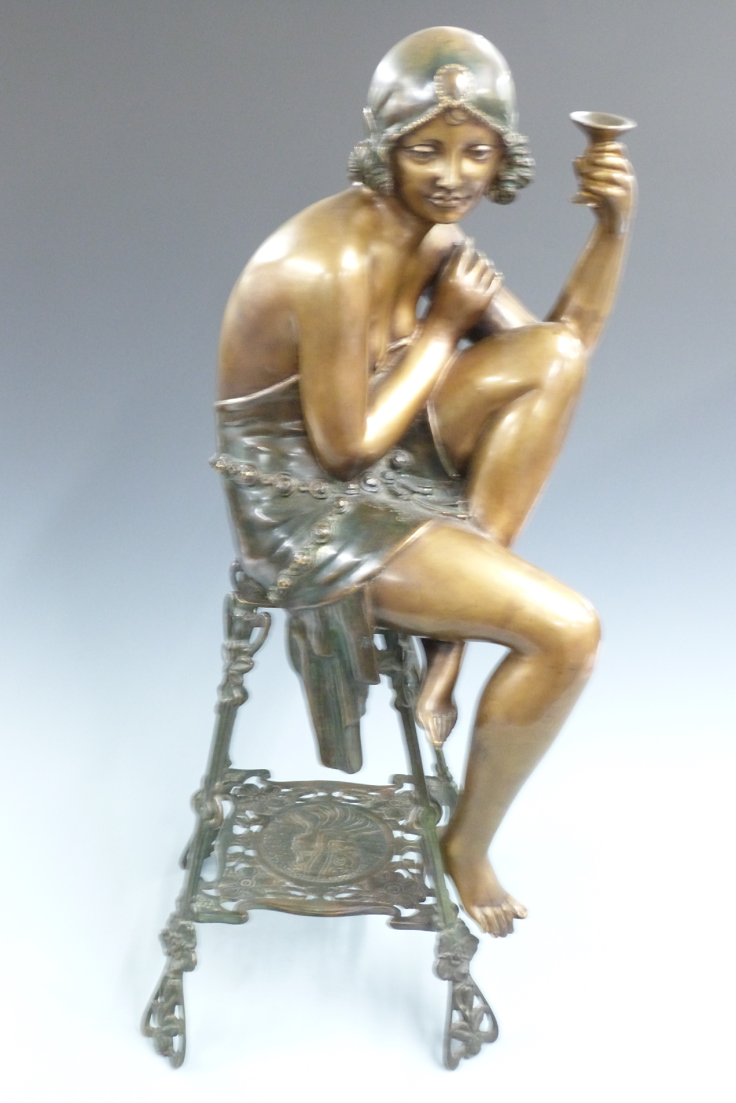 Art Deco style bronze/bronzed flapper girl with champagne glass seated on an ornate Art Nouveau