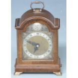 Elliott mantel clock in arched mahogany case, the silvered Roman chapter ring on bronzed dial with