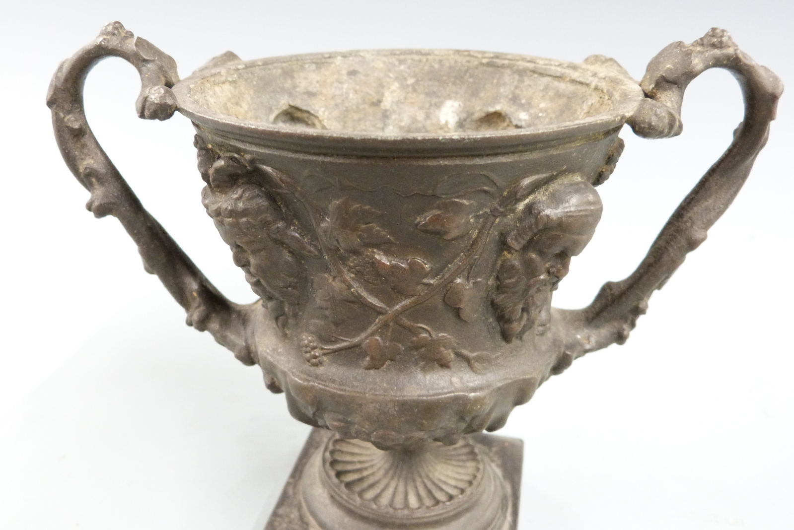 Spelter miniature twin handled vase or urn with mask and foliate decoration, on square slate or - Bild 2 aus 2