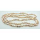 A cultured pearl necklace made up of peach, pink and cream beads