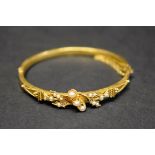 A Victorian 15ct gold hinged bangle, decorated holly leaf and split pearls, 8g total weight.