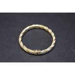 An engine turned 9ct gold bangle, 10g.